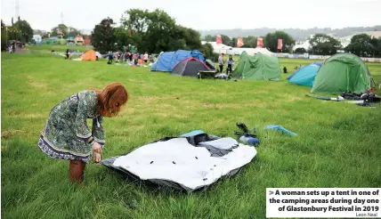  ?? Leon Neal ?? > A woman sets up a tent in one of the camping areas during day one of Glastonbur­y Festival in 2019