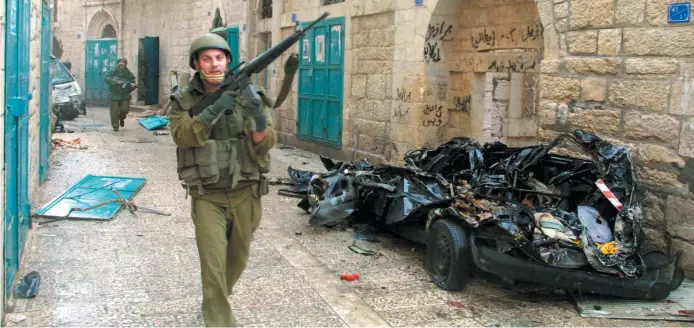  ?? - Archives ?? Le conflit qui oppose Israëliens et Palestinie­ns est silencieux et fait en moyenne des dizaines de morts chaque année. Cette photo datant d’avril 2002 montre un soldat israëlien de Béthléem.
