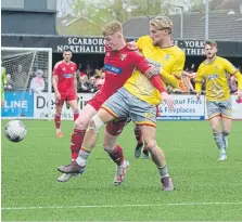  ?? ?? Alex Wiles holds off a Town player.