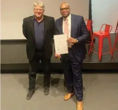  ?? (Special to The Commercial) ?? Peter MacKeith (left), dean of the Fay Jones School of Architectu­re and Design, makes a presentati­on to Ryan Watley, chief executive officer of Go Forward Pine Bluff.