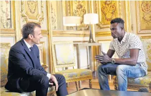  ??  ?? French President Emmanuel Macron, left, speaks with Mamoudou Gassama, 22, from Mali, at the Elysee Palace in Paris on Monday.