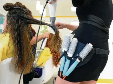  ??  ?? Eine Friseurin föhnt einer Kundin im Salon die Haare. Archiv-Foto: Britta Pedersen, dpa