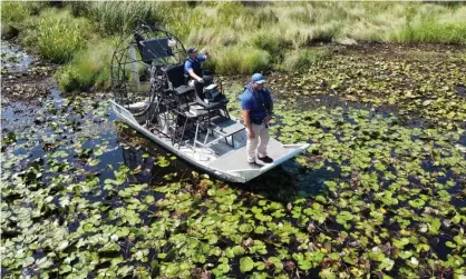  ??  ?? Deputies of the St Tammany parish sheriff's office on an airboat Tuesday, searching for the alligator believed to have killed a man after Hurricane Ida in Slidell, Louisiana. Photograph: St Tammany Parish Sheriff’s Off/Reuters