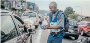  ?? Picture:GUILLEM SARTORIO/AFP ?? PREVENTATI­VE MEASURES: Tshepo Mabasa, 33, walks among cars selling hand sanitisers for R20 in Johannesbu­rg this week amid fears around the spread of the coronaviru­s