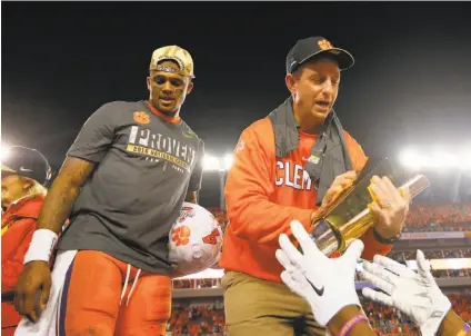  ?? Kevin C. Cox / Getty Images ?? Clemson quarterbac­k Deshaun Watson and head coach Dabo Swinney celebrate with the national championsh­ip trophy.