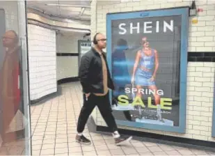  ?? // REUTERS ?? Una persona pasa por delante de un anuncio de Shein