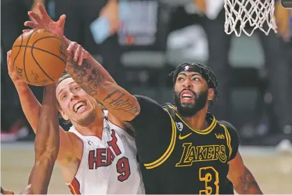  ?? MARK J. TERRILL/ASSOCIATED PRESS ?? Heat forward Kelly Olynyk, left, battles Lakers forward Anthony Davis for a rebound Friday in Game 2 of the NBA Finals in Lake Buena Vista, Fla. The Lakers have dominated both games and lead the best-of-seven series 2-0.