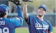  ?? ROBERT GAUTHIER TNS ?? Dodgers ace pitcher Clayton Kershaw high-fives teammate Hyun-jin Ryu following a warm-up session on Feb. 15, in Glendale, Ariz.