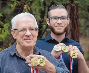  ?? GREG SORBER/JOURNAL ?? Jim and Kyle Martin display their medals that represent their five world records in flight archery.