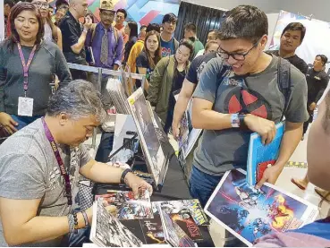  ??  ?? Hero story: Local Pinoy fans lined up around the block to have their comic books and memorabili­a signed by famed comic artist Whilce Portacio.