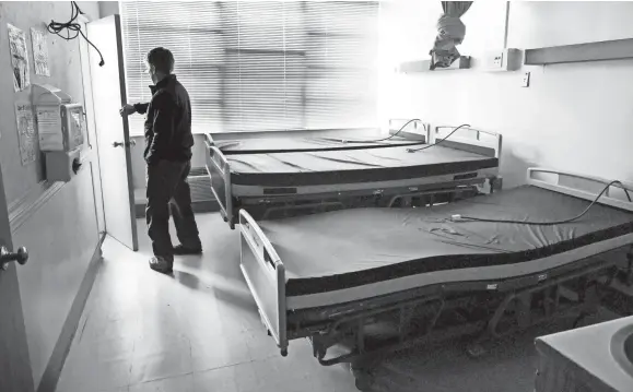  ?? SHELLEY MAYS/THE TENNESSEAN ?? Mayor of Ducktown Mayor Doug Collins stands in the doorway of a room where hospital beds have been stored inside town's shuttered hospital in Ducktown, Tennessee on Dec. 5, 2018. Copper Basin Medical Center closed due to mounting debt.