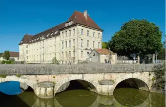  ??  ?? Sur les bords du canal des Tanneurs, l’ancien hôpital général de la Charité, élégant bâtiment du xviiie siècle classé au titre des monuments historique­s, est devenu le lycée Charles Nodier en 1967.