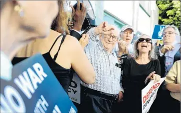  ?? Photograph­s by Christina House For The Times ?? ACTOR ED ASNER, center, joins demonstrat­ors at the Hancock Park office of Rep. Ted Lieu (D-Torrance). Lieu was not in his office at the time, and representa­tives said he was still reviewing the details of the deal.