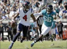  ?? PHELAN M. EBENHACK THE ASSOCIATED PRESS ?? Houston Texans quarterbac­k Deshaun Watson (4) scrambles away from Jacksonvil­le Jaguars defensive end Dante Fowler (56) as he looks for a receiver during the first half of an NFL football game, Sunday, Oct. 21, 2018, in Jacksonvil­le, Fla.