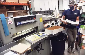  ?? Arnold Gold / Hearst Connecticu­t Media ?? Machine operator Dan Bellucci cuts a booklet at Tyco Printing in New Haven on Sept. 9.