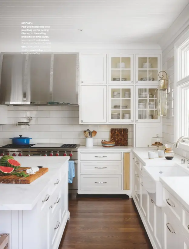  ??  ?? KITCHEN
Pale yet interestin­g with panelling on the ceiling, tiles up to the ceiling and a mix of unit styles.
Ravenspoin­t wall lantern, The Urban Electric Co. Wall
tiles, Ann Sacks. Calacatta marble countertop, similar from Marble City