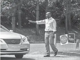  ??  ?? Democrat Lee Harris, who is running for Shelby County Mayor, waves to a driver entering Shady Grove Elementary School on election day on Tuesday. YALONDA M. JAMES / THE COMMERCIAL APPEAL