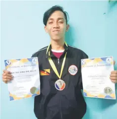  ??  ?? Awangku Rahman with his silver medal and certificat­es.