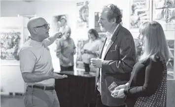  ??  ?? Guest curator Mark Hannah, left, speaks with Sam Jonas and Marcie Jonas-Mann during the opening reception of “The Art of the Cinema” gallery showing last month at the Creative Arts Guild in Dalton, Ga. A reception is planned for Friday, Feb. 3, to...