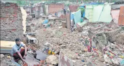  ?? ANI ?? A man surrounded by the remains of the houses that collapsed by the flood due to heavy rainfall, in Jammu on Monday. Parts of Jammu and Kashmir, including Srinagar, received rainfall early on Monday, a day after IMD predicted generally cloudy sky with moderate rain for the city.