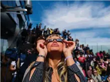  ?? (NEW YORK, 8 AVRIL 2024/SPENCER PLATT/GETTY IMAGES/AFP) ?? Lunettes protectric­es sur le nez, des milliers de New-Yorkais se sont rassemblés lundi sur les toits de gratte-ciel.