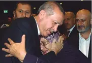  ?? — AP ?? Turkish President Recep Tayyip Erdogan hugs a woman in Ankara on Friday at an event to honour those killed and wounded during the failed July 15 military coup.