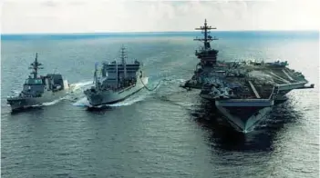  ??  ?? The aircraft carrier USS Theodore Roosevelt transits alongside the Indian Deepak class fleet tanker INS Shakti during a replenishm­ent-at-sea exercise as the Japanese Maritime Self-Defense Force Akizuki class destroyer
JS Fuyuzuki approaches during...