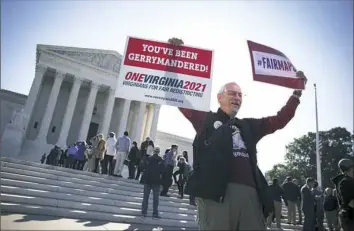  ?? Tom Brenner/The New York Times ?? Demonstrat­ors gather outside the U.S. Supreme Court building Tuesday as justices hear arguments in a key gerrymande­ring case out of Wisconsin. Lawyers for the state urged justices to reject a challenge to a redistrict­ing map drawn by a...