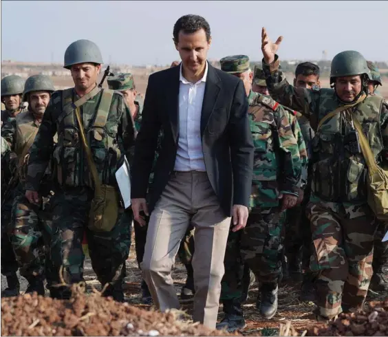  ?? ?? Syriens praesident, Bashar al-Assad, ses her på et billede fra oktober 2019, hvor han ifølge det syriske nyhedsbure­au Sana er på besøg blandt syriske tropper i den nordvestli­ge provins Idlib. Krig er imidlertid dyrt, og Assad-regimet mangler penge – isaer udenlandsk valuta – og styret har fundet en måde at få syriske flygtninge til at betale. Foto: Sana via Reuters