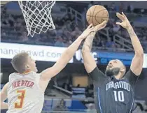  ?? PHELAN M. EBENHACK/AP ?? Magic guard Evan Fournier goes up for a shot in front of Hawks guard Kevin Huerter on Monday night at Amway Center.