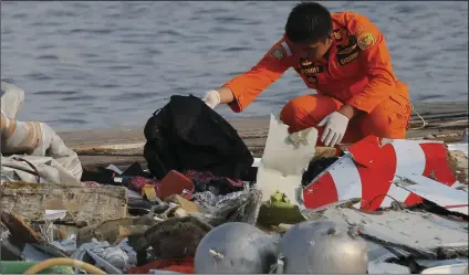  ??  ?? A member of Indonesian Search and Rescue Agency (BASARNAS) inspects debris believed to be from Lion Air passenger jet that crashed off Java Island at Tanjung Priok Port in Jakarta, Indonesia on Monday. AP PHOTO/TATAN SYUFLANA