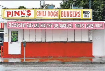  ?? Frederic J. Brown AFP/ Getty I mages ?? A MESSAGE in April from L. A.’ s most famous hot dog stand urges the city to “Please Stay Safe and Healthy.” The 81- year- old business is shutting down voluntaril­y through at least March because of the pandemic.