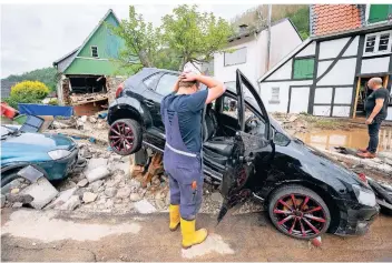  ?? FOTO: JULIAN STRATENSCH­ULTE/DPA ?? Ein Anwohner steht in Hagen vor seinem zerstörten Auto.