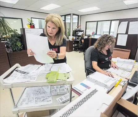  ?? JULIE JOCSAK THE ST. CATHARINES STANDARD ?? City Clerk, Bonnie Nistico-Dunk, left, and Rebecca Alfieri, elections co-ordinator for the legal and clerks services for the City of St. Catharines, are inundated during the final business hours following election submission deadlines at the St. Catharines Clerks Office on Friday.