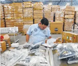  ?? ASSOCIATED PRESS FILE PHOTO ?? In June, Claudio Montes checks a shipping manifest for U.S. manufactur­ed parts heading to assembly plants in Mexico at Freight Dispatch Service Agency LTD in Pharr, Texas. The freight service ships parts between the U.S. and Mexico that pass through...