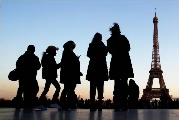  ??  ?? People stand at the Trocadero square near the Eiffel Tower in Paris, France. Next year corporate tax is due to be cut from 33.3 per cent to 31 per cent as part of a gradual decrease over the course of Macron’s presidency. — Reuters photo