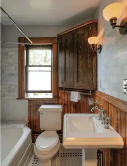  ??  ?? LEFT Wainscot is old, tile new in the tiny master bathroom. The marble seat and new corner cabinet stretch space. The ca. 1920 towel bars were salvaged from the old Sagamore Hotel at Lake George, New York. BELOW The front porch was replicated. An...