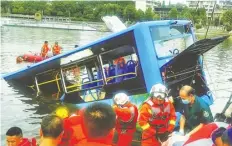  ?? STR/AFP ?? EVAKUASI: Petugas diturunkan untuk mencari korban kecelakaan bus yang masuk ke waduk di Anshun, Guizhou, Tiongkok, pada Selasa (7/7).