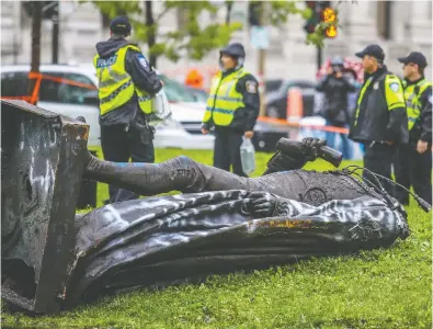  ?? JOHN MAHONEY / POSTMEDIA NEWS FILES ?? The headless statue of Sir John A. Macdonald on the ground in Montreal after a demonstrat­ion in August.