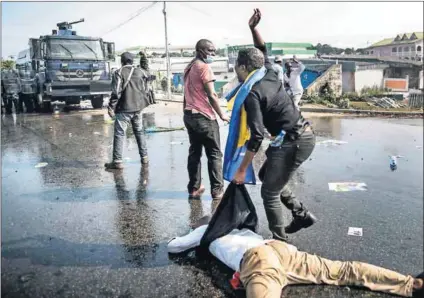  ?? Photos: Marco Longari/ AFP ?? Victim of unrest: A wounded supporter (above) of Gabonese opposition leader Jean Ping in Libreville during clashes with riot police as protests sparked after Ali Bongo’s re-election. A distressed woman (left) reacts as she waits to hear about the...