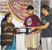  ?? Photo courtesy of CRyptonite team ?? Cinco Ranch High graduate Abhishek Routray, right, and his brother, Anuraag Routray, a student at Beck Junior High, present a LEGO Mindstorms kit to JNV’s principal, Hemlatha Unnikrishn­an.