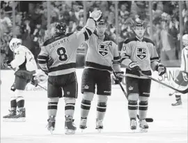  ?? Ryan Kang Associated Press ?? JEFF CARTER, center, high-fives defenseman Drew Doughty after a Kings goal against the Capitals on Saturday. At right is teammate Tanner Pearson.