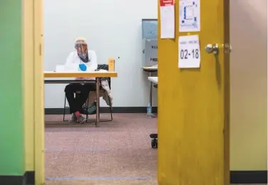  ?? Z Long / Associated Press ?? Election worker Sharon Beverly waits for voters during the Nebraska primary. in Omaha, Neb. Precinct sites had social distancing measures in place to prevent the spread of the coronaviru­s.