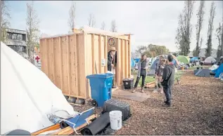  ?? ETHAN SWOPE — SPECIAL TO THE MARIN INDEPENDEN­T JOURNAL ?? Daniel Francis Eggink, 83, and his daughter Cynthis Eggink, center, at a partially finished structure built at Marinship Park in Sausalito.