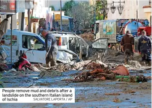  ?? SALVATORE LAPORTA / AP ?? People remove mud and debris after a landslide on the southern Italian island of Ischia