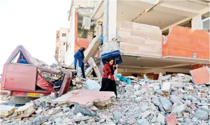  ??  ?? Iranians salvage items from damaged buildings in the town of Sarpol-e Zahab in the western Kermanshah province near the border with Iraq, on Tuesday.(AFP)