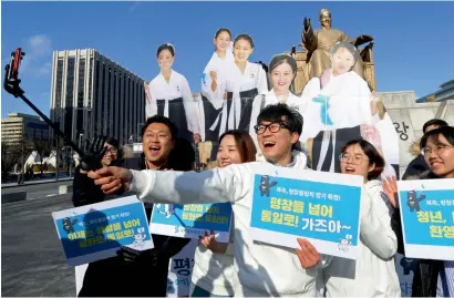  ?? AP ?? College students take a selfie with cutouts of North Korean cheerleade­rs during a rally in Seoul on Wednesday. —