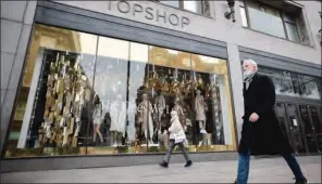  ?? (TOLGA AKMEN/AFP) ?? A pedestrian wearing a face covering due to the COVID-19 pandemic, walks past a closed-down Topshop clothes store, operated by Arcadia, on Oxford Street in central London.