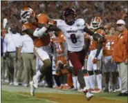  ?? RAINIER EHRHARDT — THE ASSOCIATED PRESS ?? Louisville quarterbac­k Lamar Jackson (8) stiff-arms Clemson safety Van Smith (23) as he goes out of bounds during the second half of an NCAA college football game on Saturday in Clemson, S.C. Clemson won 42-36.