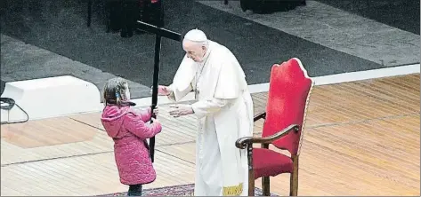  ?? VATICAN MEDIA HANDOUT / EFE ?? El papa Francesc rep la creu d’una nena a la plaça, gairebé deserta, de Sant Pere del Vaticà